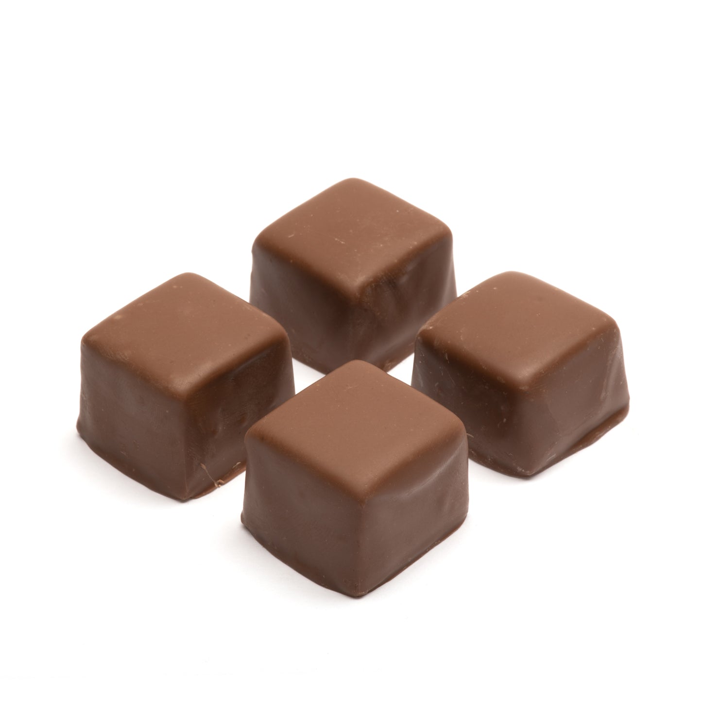 Four milk chocolate caramel squares on a white background