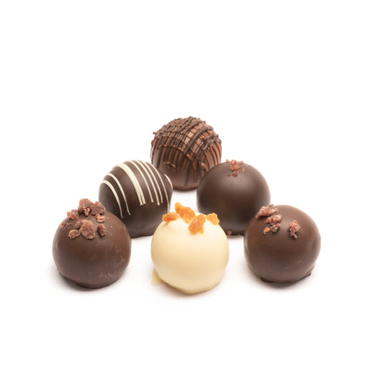 An assortment of 6 Euphoria Chocolate Company truffles in milk, dark, and white chocolate against a white background.