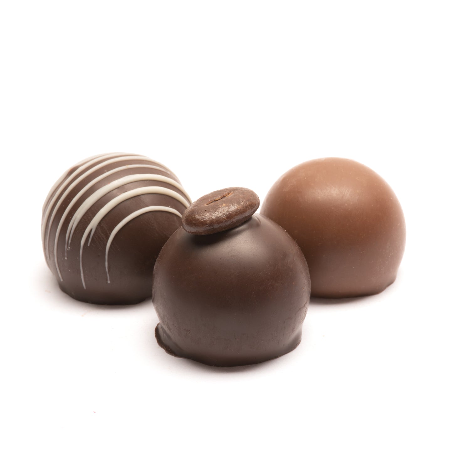An assortment of 3 chocolate truffles with different toppings and designs, including a shiny milk chocolate truffle, a dark chocolate truffle topped with a coffee bean, and a dark chocolate truffle with mint stripes.