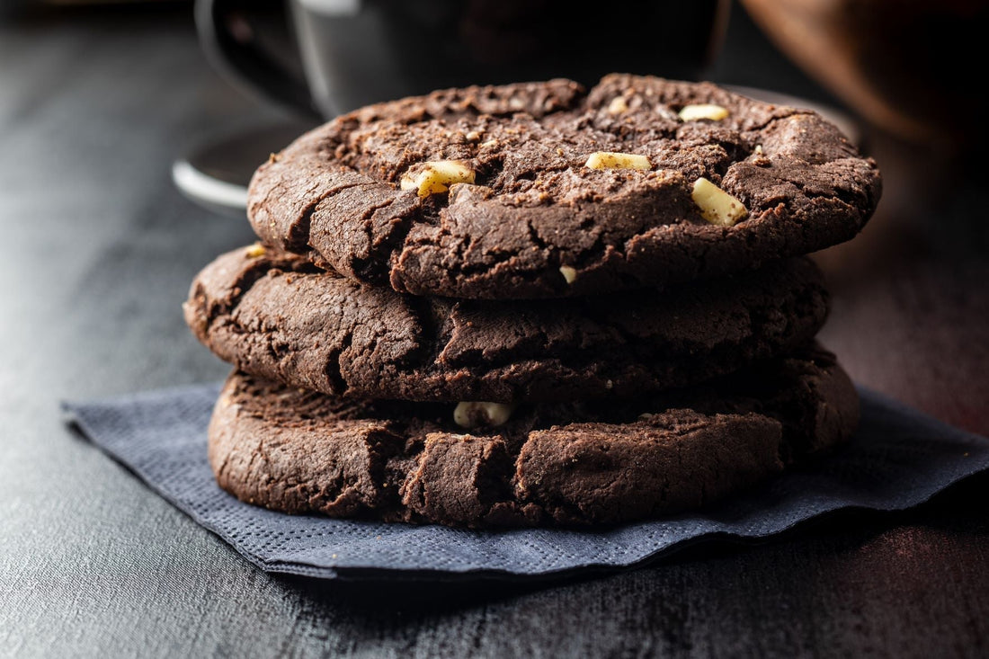 A stack of chocolate cookies with white chips.