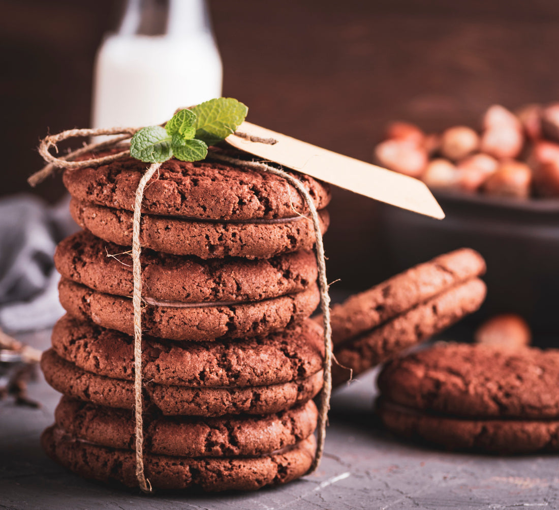 A stack of chocolate cookies bound together with twine and a mint leaf.