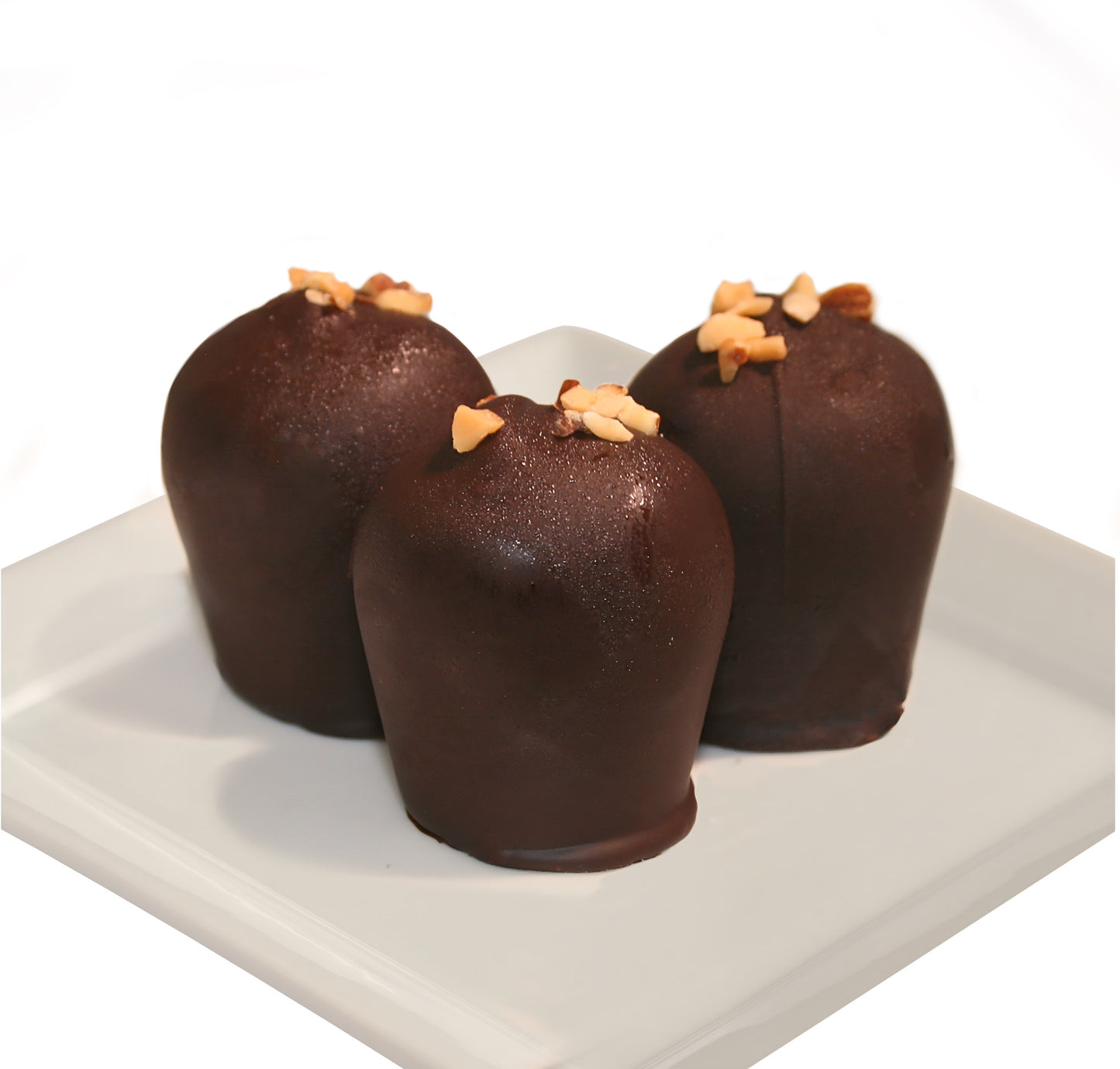Three dark chocolate truffles with slivered almonds on top on a white plate against a white background.
