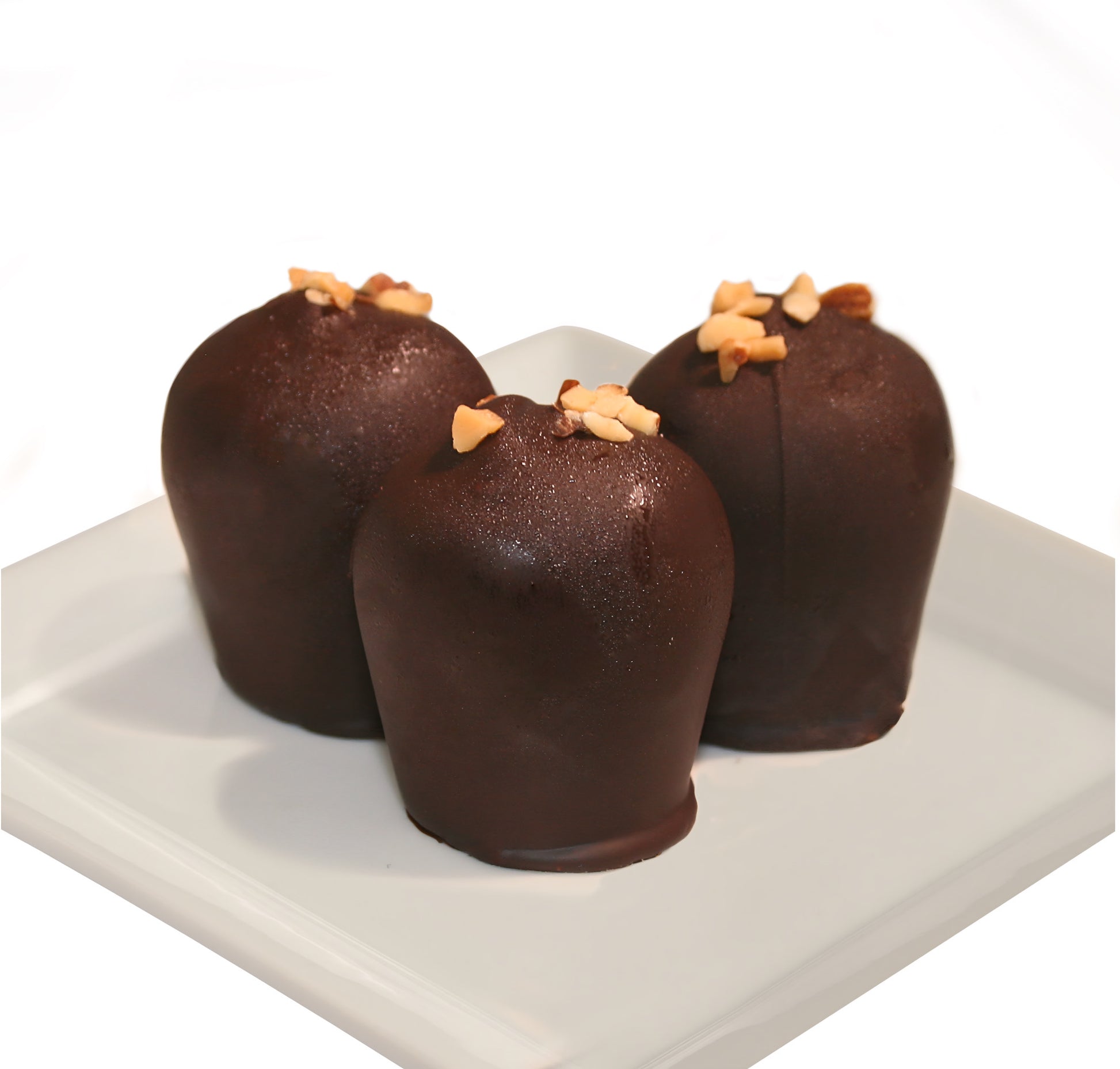 Three dark chocolate truffles with slivered almonds on top on a white plate against a white background.