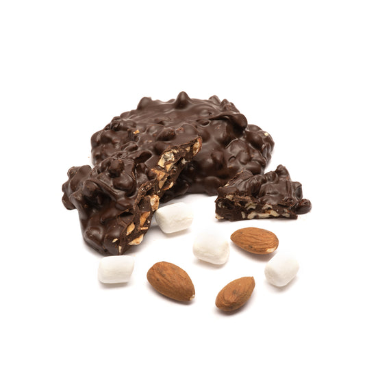 Dark chocolate-covered rocky road cluster with almonds and marshmallows on a white background