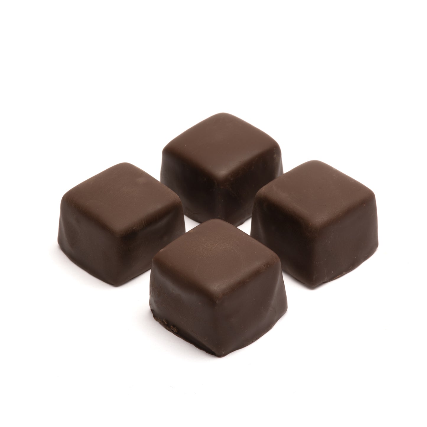 Four dark chocolate caramel squares on a white background