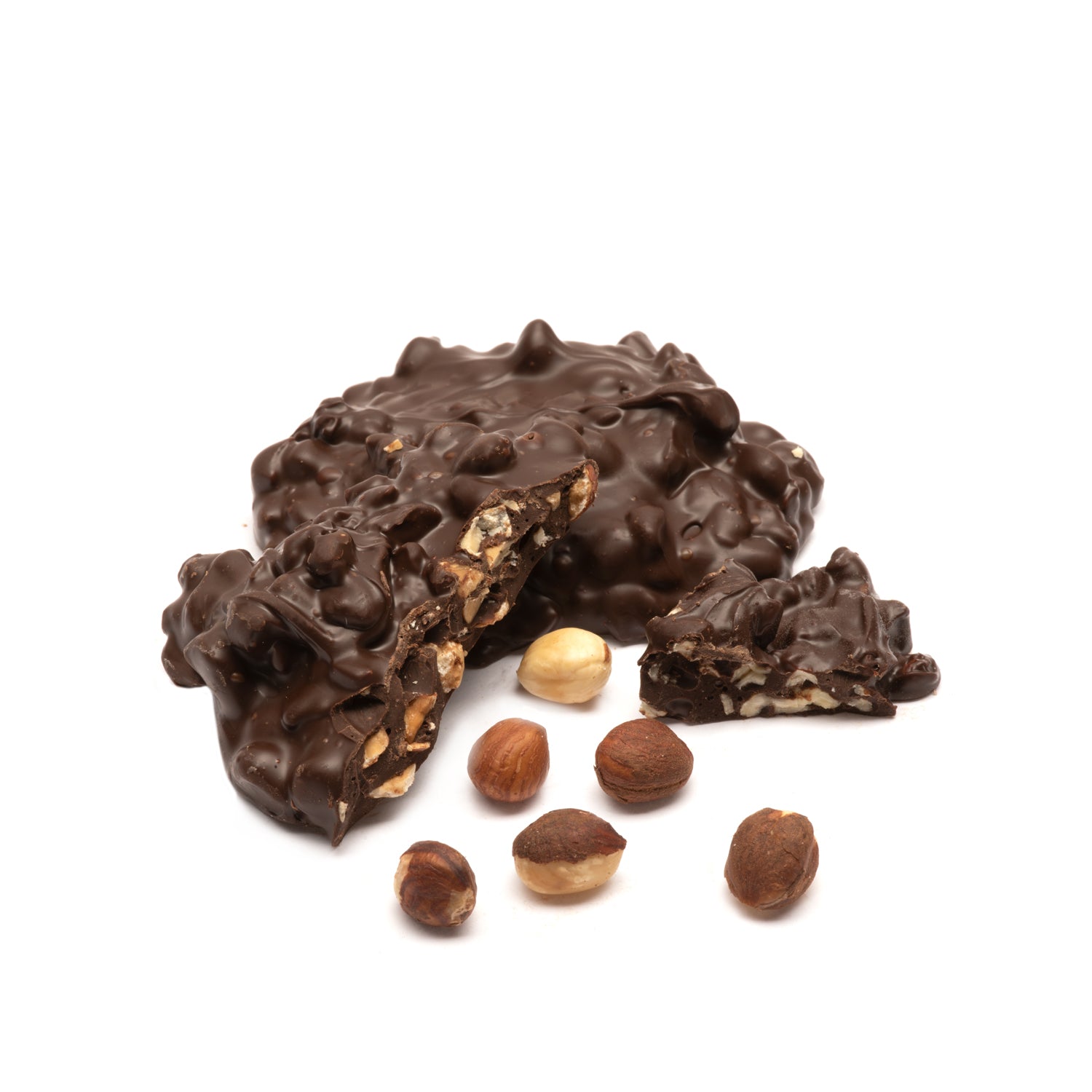 Dark chocolate-covered hazelnut cluster with hazelnuts on a white background