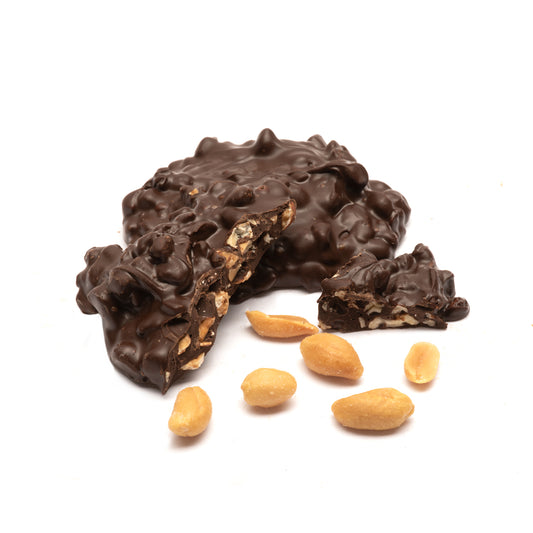 Dark chocolate-covered peanut cluster with peanuts on a white background