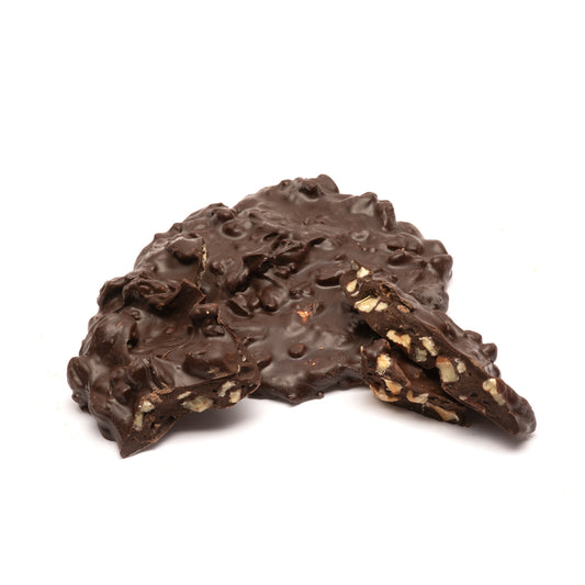 Dark chocolate nut cluster with a textured surface on a white background