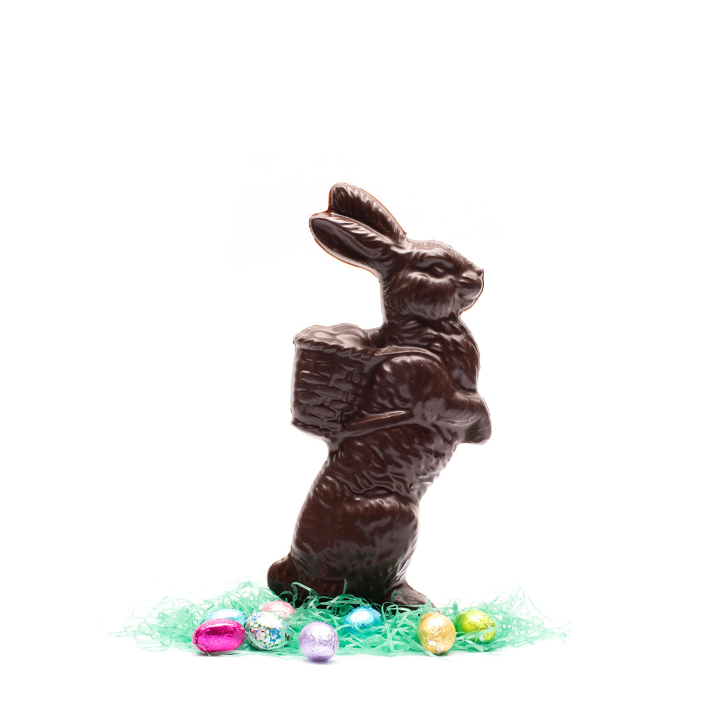 Dark chocolate rabbit carrying a basket on a white background
