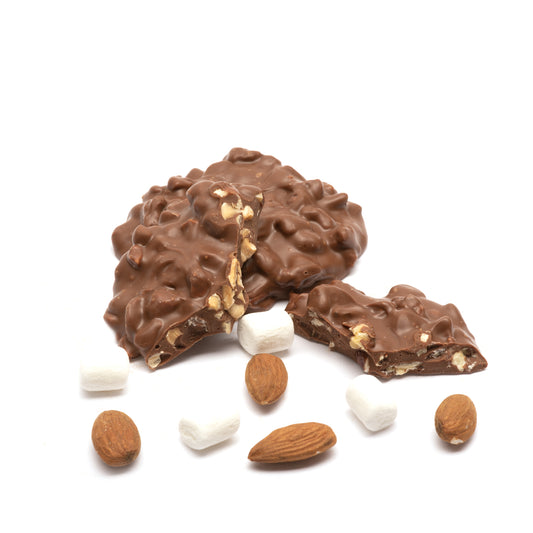 Milk chocolate rocky road cluster with almonds and marshmallows on a white background
