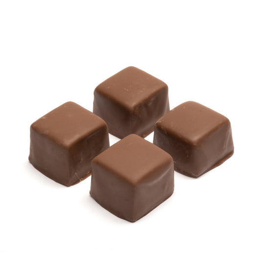 Four milk chocolate caramel squares on a white background
