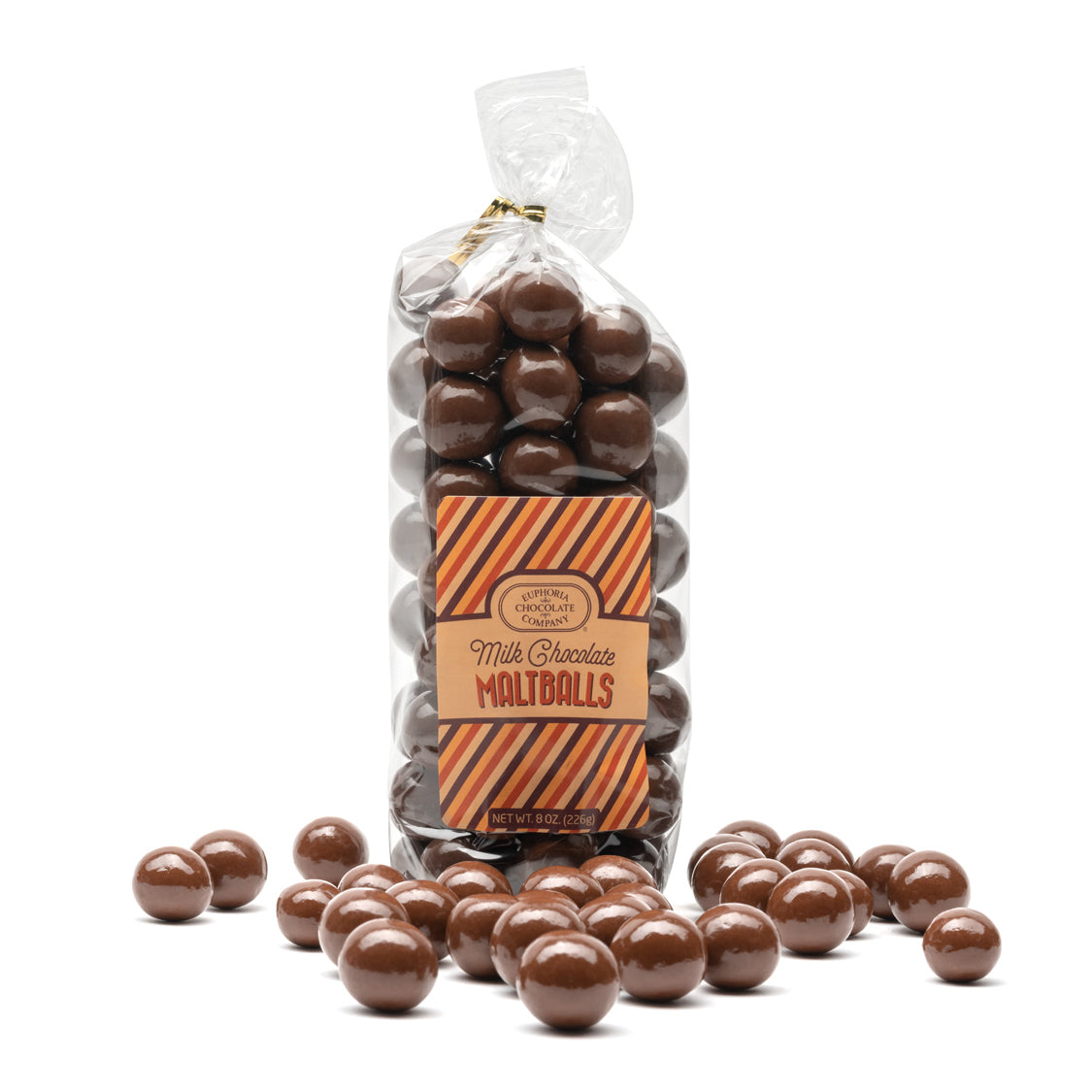 Bag of milk chocolate maltballs with a clear top, surrounded by additional maltballs on a white background.