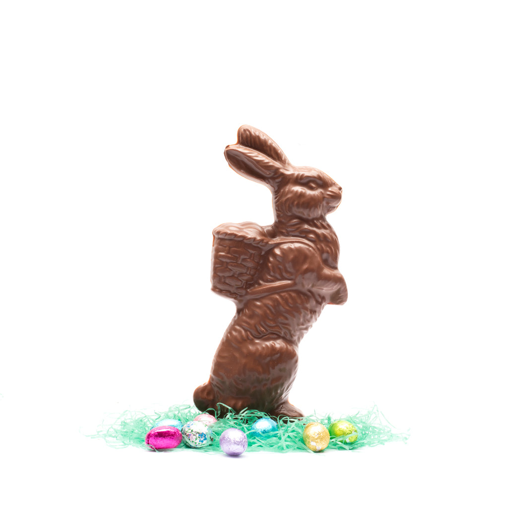 Milk chocolate rabbit carrying a basket on a white background