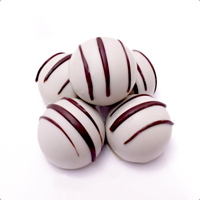 Four white chocolate truffles with brown stripes on a white background