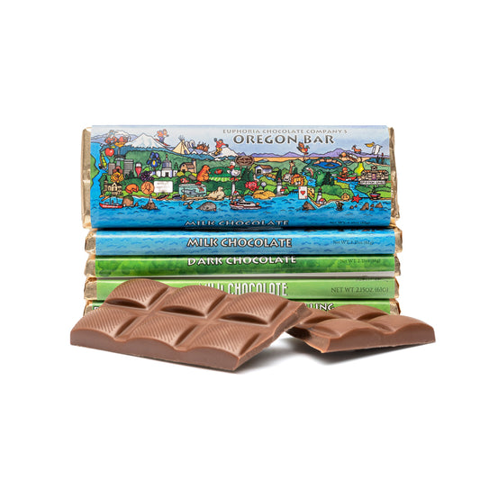 Stack of Euphoria Chocolate Company chocolate bars with colorful packaging featuring a scenic design, on a white background.