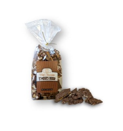A clear bag of Euphoria Chocolate Company's milk chocolate smores bark with pieces sitting next to the bag.