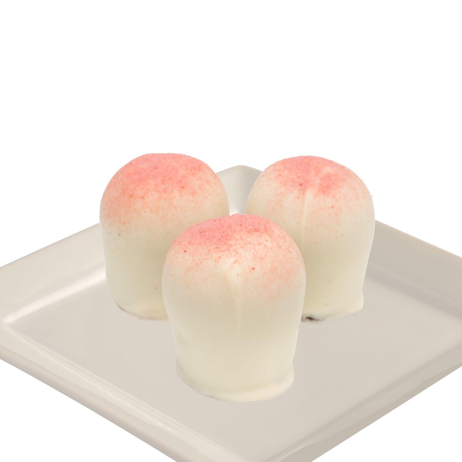 Three white truffles with a pink confection dust on a white plate