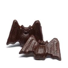 Dark chocolate bat-shaped candy on a white background