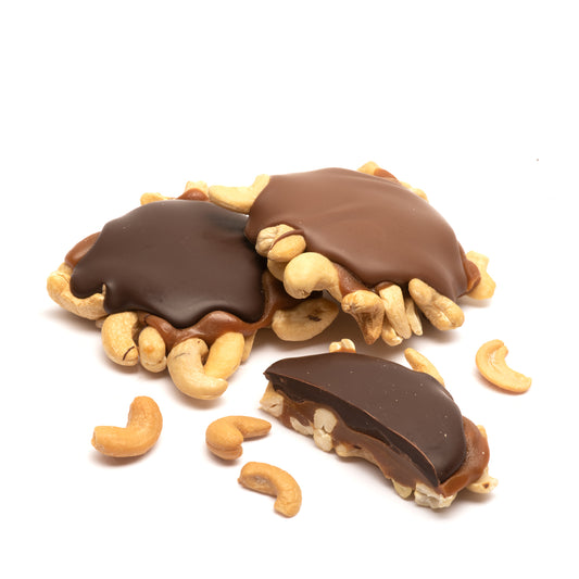 Chocolate and caramel-covered cashews on a white background