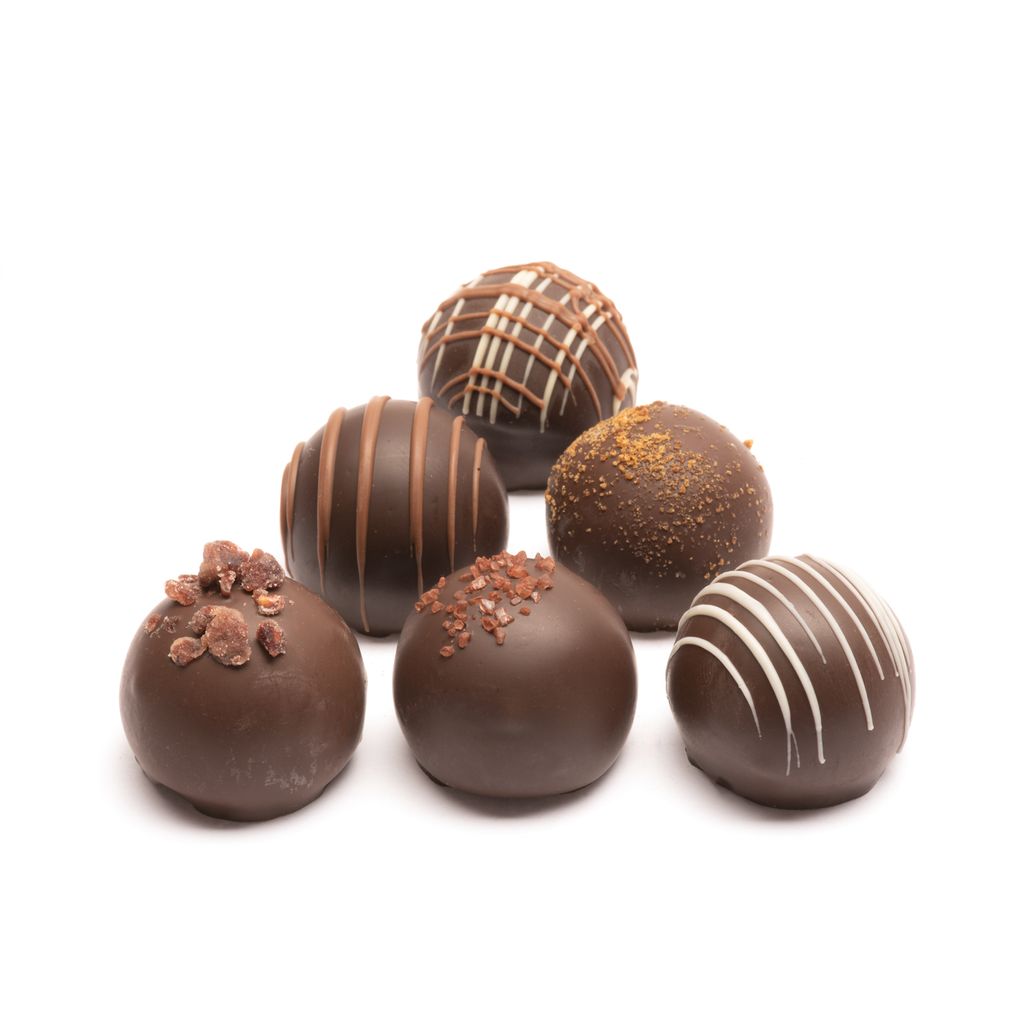 Assorted dark chocolate truffles on a white background