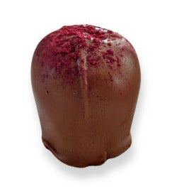 Chocolate truffle with marionberry powder on a white background