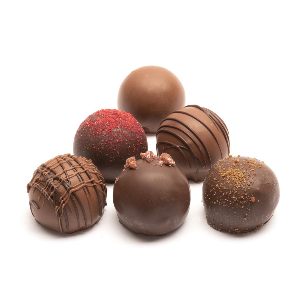 Assorted milk chocolate truffles on a white background