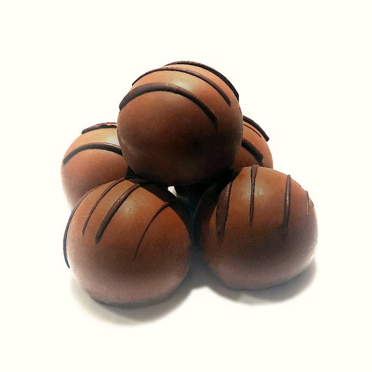 Stack of chocolate truffles with darker chocolate stripes on a white background