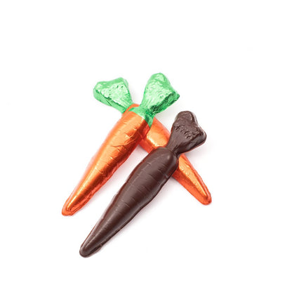 Two green-and-orange foil wrapped carrots with one unwrapped, showing a textured dark chocolate carrot against a white background.
