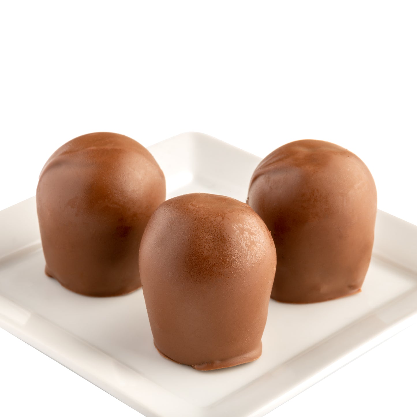 Three milk chocolate truffles with a smooth chocolate coating on a white plate with a white background.