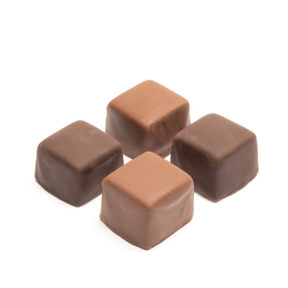 A selection of caramel squares in milk and dark chocolate, presented on a white background.