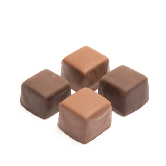 A selection of caramel squares in milk and dark chocolate, presented on a white background.
