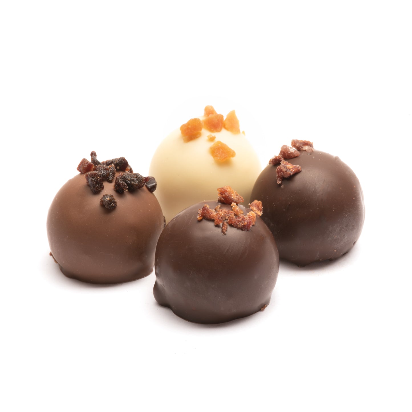 A collection of chocolate truffles with fruit toppings, presented against a white background.