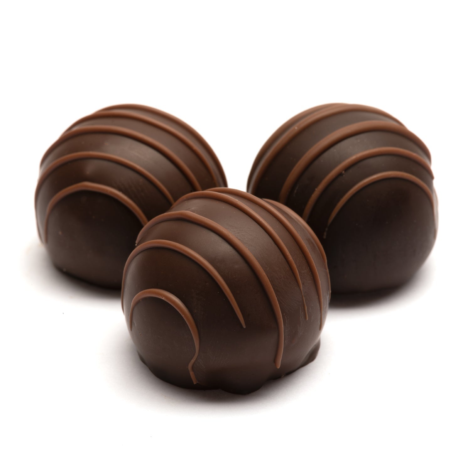 A set of three Euphoria Chocolate Company chocolate truffles with dark chocolate shells and milk chocolate stripes on top, against a white background.