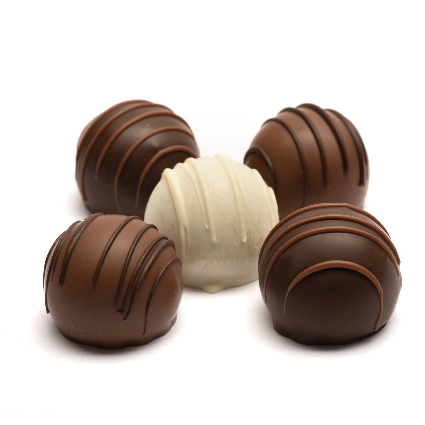 A selection of 5 mlik, dark, and white chocolate truffles with varying patterns, representing different wine and chocolate combinations.