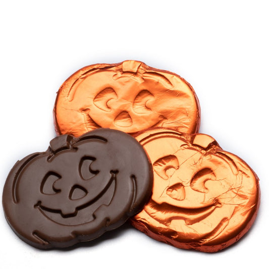 Two foil-wrapped chocolate pumpkins, with an unwrapped dark chocolate pumpkin displaying the inside product against a white background.